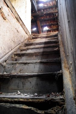 Harap olmuş bir binanın eski tavan arası merdivenleri. Kirli bir evin karanlık ve gizemli bir köşesi.