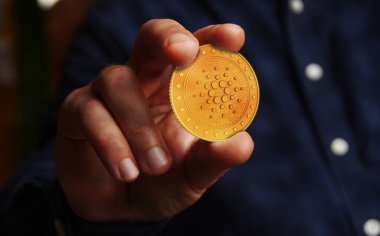 Cardano Ada kripto para sembolü. Eldeki altın para soyut kavram..
