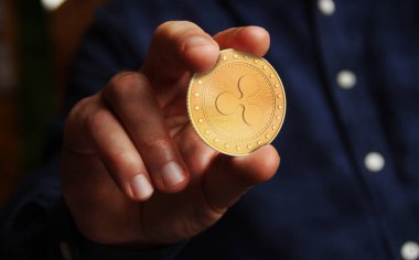 Dalgalanan XRP kripto para sembolü elde bulunan altın para soyut konsept.