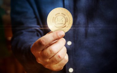 Monero XMR kripto para sembolü. Eldeki altın para soyut kavram..