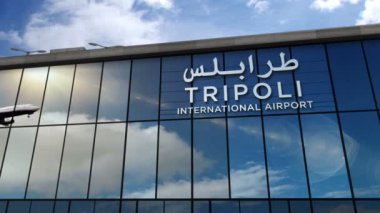 Libya, Trablus 'a iniş yapan bir jet uçağı canlandırma yapıyor. Cam havaalanı terminali ve uçağın yansıması ile şehre varış. Seyahat, iş, turizm ve ulaşım kavramı.