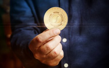 Filecoin FIL kripto para sembolü elde bulunan altın para soyut konsept.
