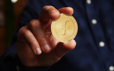 Filecoin FIL kripto para sembolü elde bulunan altın para soyut konsept.