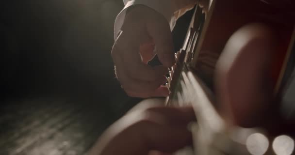 Les mains masculines jouent de la guitare acoustique dans les rayons de lumière. Gros plan. V3 — Video