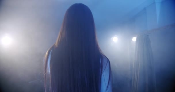La cantante se para con su espalda a la cámara y comienza a cantar, la escena en el humo V6 — Vídeos de Stock