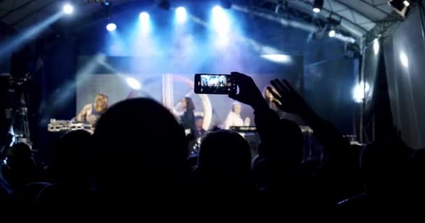 Blured Silhouette med människor som håller upp händerna på en konsert. Långsamma rörelser V7 — Stockvideo