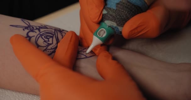 Tatuerare gör en tatuering på en arm, jobbar i studio. Närbild Slow motion V4 — Stockvideo