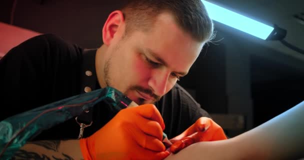 Tetování umělec dělá tetování na ruce, pracuje ve studiu. Pohled zblízka Zpomalený pohyb V6 — Stock video