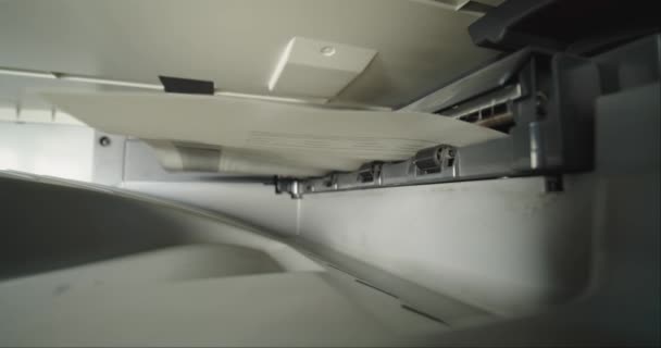 Kantoorlaserstraalprinter die een pagina papier drukt. Sluiten. — Stockvideo