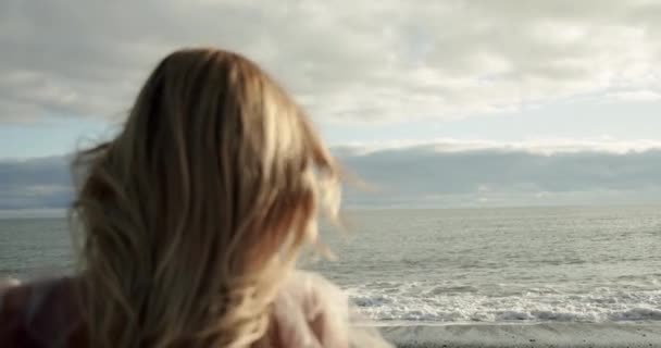 Bulanık kadın denizin arka planında. Rüzgarda uçuşan uzun saçlar. Yavaş çekim — Stok video