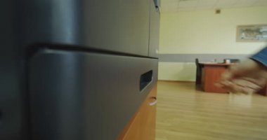 Kapatın. Ofisteki yazıcıya kağıt koyan bir kadının elleri..