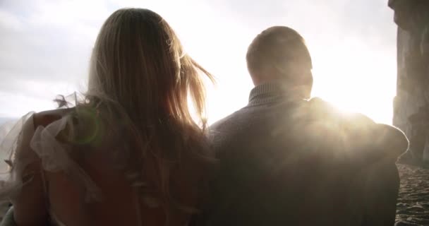 Αγαπημένο ζευγάρι που κάθονται μαζί στις ακτίνες του ήλιου. Κλείσιμο Αργή κίνηση — Αρχείο Βίντεο