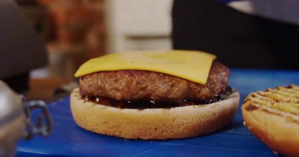 Faire un burger au fromage. Le chef prend du fromage pour préparer un burger. Fermez. — Video