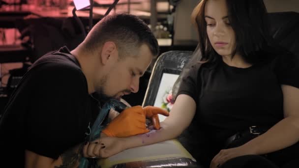 Tatoueuse fait une femme tatouée sur un bras, travaille en studio. Mouvement lent — Video