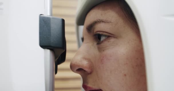 Офтальмологія - перевіряє очі жінки-лікаря, що працює з протестованими машиною очима. крупним планом . — стокове відео