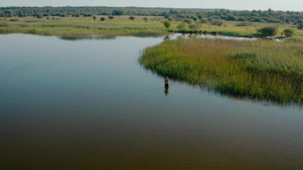 Vista aérea del dron. Un hombre está pescando en el lago. — Vídeo de stock
