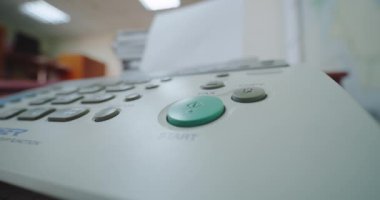 Faksı kullanan bir kadının eli, düğmeye basar ve telefonu açar..