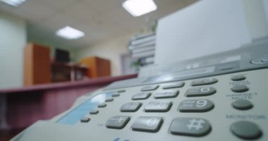 Kapatın. Faksla bir kadının eli, düğmeye basar ve telefonu kaldırır, geniş açı.