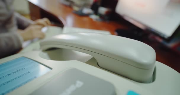 Közelkép irodai dolgozó, női kéz felveszi a telefont egy fax gép. — Stock videók