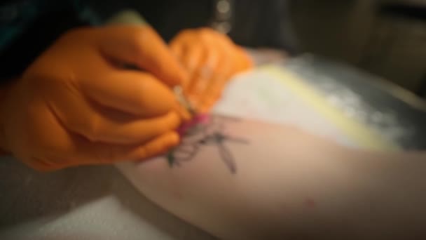 Tatuażysta robi tatuażystkę na ramieniu, pracuje w studio. Powolny ruch Szeroki widok — Wideo stockowe