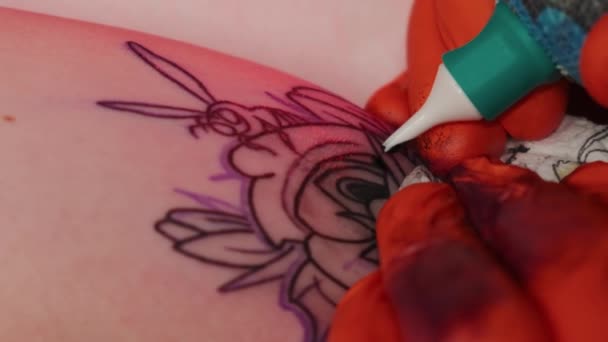 Tatuaje artista hace una mujer tatuaje en un brazo, trabaja en el estudio en la luz roja. Cámara lenta Cerrar vista — Vídeos de Stock