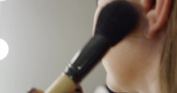 Chiudete. Truccatore professionista mettendo il rossore con il make up pennello sul viso delle donne. Rallentatore — Video Stock