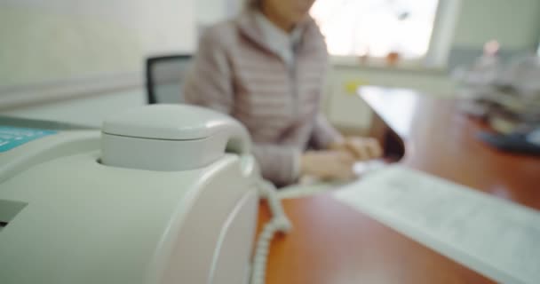 Impiegata, la mano femminile risponde al telefono con un fax. Colpo largo — Video Stock