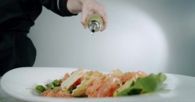 Şef kırmızı balıklı salata üzerine zeytinyağı döküyor. Yavaş çekim