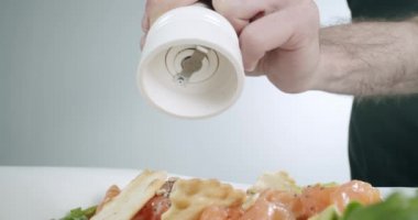 Yemek pişirirken tuz değirmeni kullanarak kaba deniz tuzu ekleyin. Yavaş çekim.