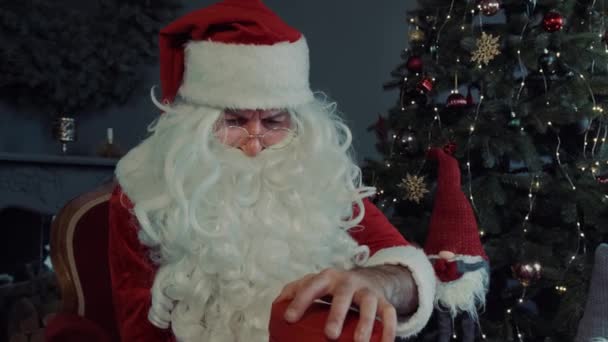 Κοντινό πορτρέτο Santa Claus ανοίγει μαγικό λαμπερό κουτί δώρου και κοιτάζει μέσα, λαμπερό φως λάμπει από κουτί. Αργή κίνηση — Αρχείο Βίντεο