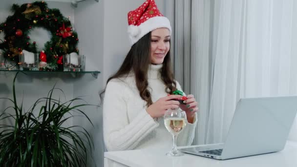 Una donna sta tenendo un regalo e digitando su un computer portatile durante una videochiamata. Vacanze Natale concetto invernale. Rallentatore — Video Stock