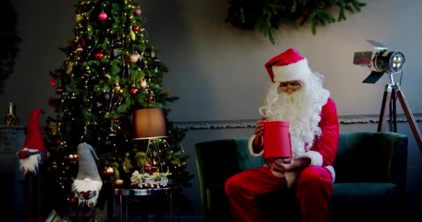 Portret Santa Claus åbner magiske glødende gaveæske og ser inde, lyse lys skinner fra kassen. Langsom bevægelse Bredt billede – Stock-video