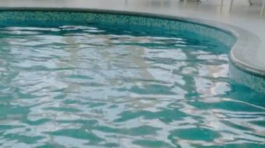 Havuzdaki saf mavi suyu ışık yansımalarıyla kapat. Yavaş çekim.