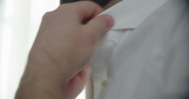Damadın sabahı, gömleğini bağlar. Yavaşça kapat.