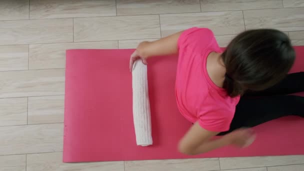 Giovane donna esegue esercizio di yoga, rilassante, sdraiato sul pavimento inizio esercizio — Video Stock