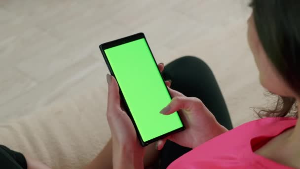 Vista de cerca de la mujer que sostiene la tecla de croma teléfono inteligente pantalla verde viendo contenido y tocando o deslizando. Vista superior — Vídeos de Stock