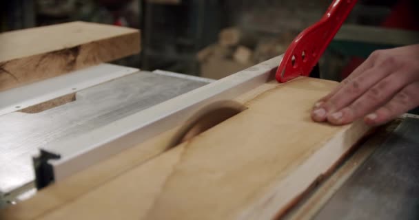 De cerca. Master corta una tabla de madera con una sierra circular en el taller de carpintería de un pequeño fabricante de muebles. En cámara lenta. V2 — Vídeos de Stock