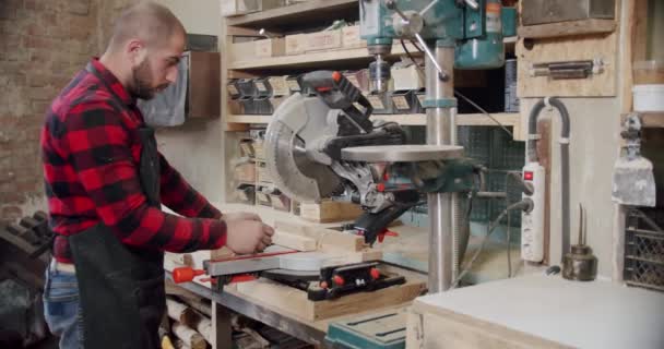 In Zeitlupe schneidet der Meister in der holzbearbeitenden Werkstatt eines kleinen Möbelherstellers ein Holzbrett mit der Kreissäge. — Stockvideo