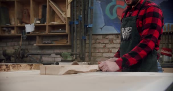 In der holzbearbeitenden Werkstatt eines kleinen Möbelherstellers schneidet der Meister mit der Kreissäge eine Holzplatte. Zeitlupe. — Stockvideo