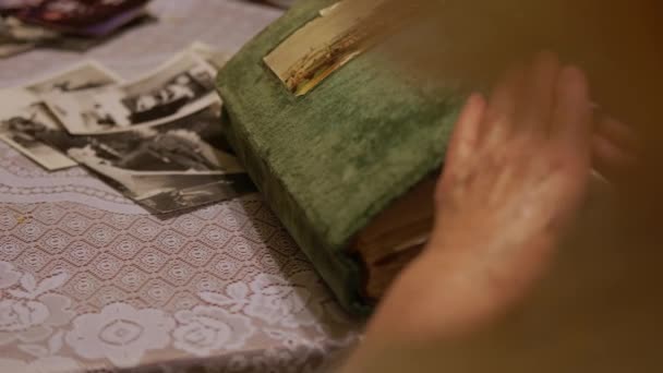 Mano anciana está mirando viejo álbum de fotos en casa. — Vídeos de Stock