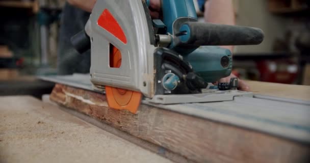 Медленное движение. Мастер режет деревянную доску циркулярной пилой в деревообрабатывающей мастерской небольшого производителя мебели. V3 — стоковое видео