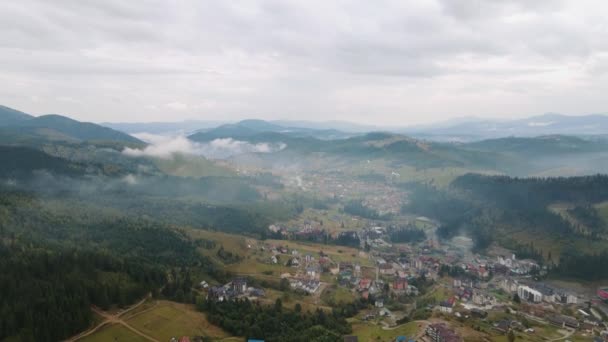 Воздушный дрон в горах. Город между горами, идет дождь и туман V3 — стоковое видео