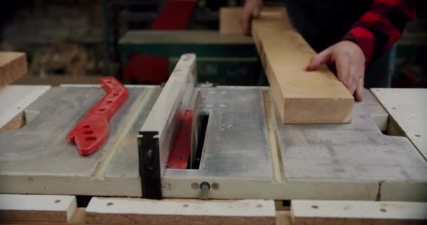 Közelről. A mester egy fa deszkát vág egy körfűrésszel egy kis bútorgyártó műhelyében. Lassú mozgás. V3. — Stock videók