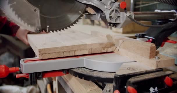 Au ralenti, le maître découpe une planche de bois avec une scie circulaire dans l'atelier de menuiserie d'un petit fabricant de meubles. V3 — Video