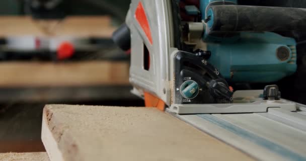 Zeitlupe. In der holzbearbeitenden Werkstatt eines kleinen Möbelherstellers schneidet der Meister mit der Kreissäge eine Holzplatte. V5 — Stockvideo