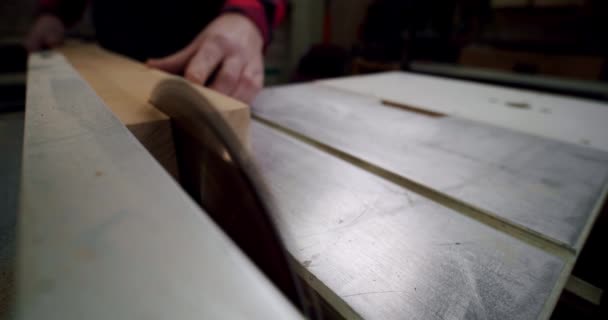 Záběr zblízka. Mistr řeže dřevěnou desku kulatou pilou v dřevoobráběcí dílně malého výrobce nábytku. Zpomal. Vercion 2 — Stock video