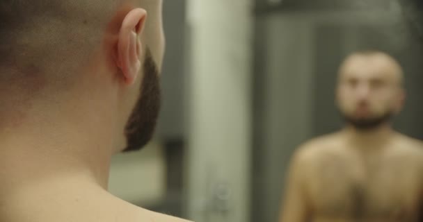 Αντανάκλαση καθρέφτη νεαρός όμορφος άντρας που αγγίζει γένια, — Αρχείο Βίντεο