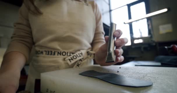 Schuss von Spezialisten, die mit Leder arbeiten, machen weibliche Hände einer Handwerkerin Löcher in einen Ledergürtel. Zeitlupe — Stockvideo