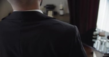 Takım elbiseli işadamı ya da damat eline saat takıyor. yavaş çekim