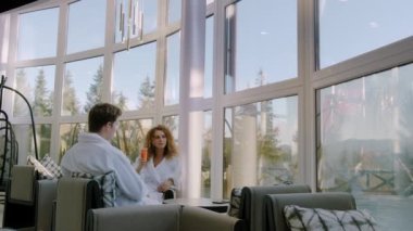 Yakın plan mutlu çift tatilde dağlarda ya da ormanlarda lüks bir spa otelinde kokteyl içiyor. yavaş çekim